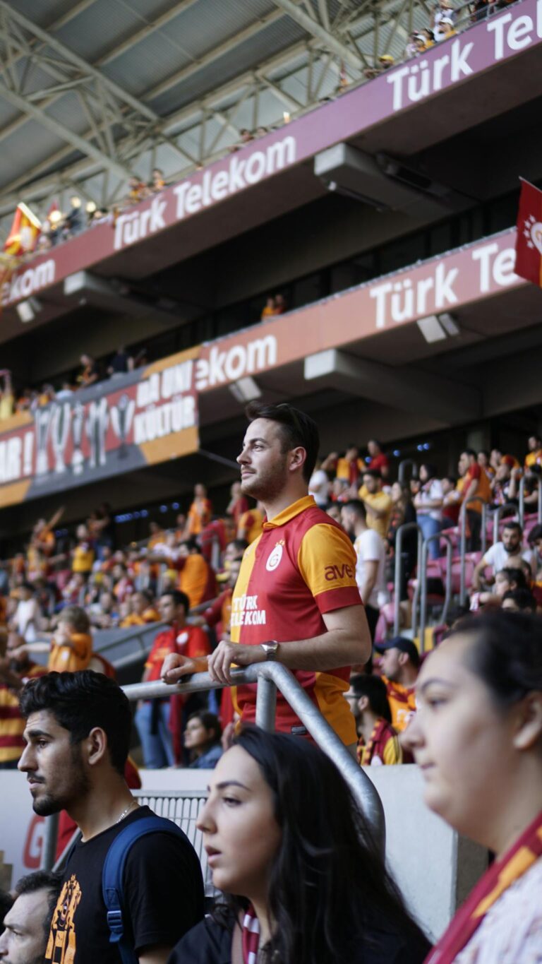 Fans cheering passionately at a football match in Türk Telekom Stadium, Istanbul.